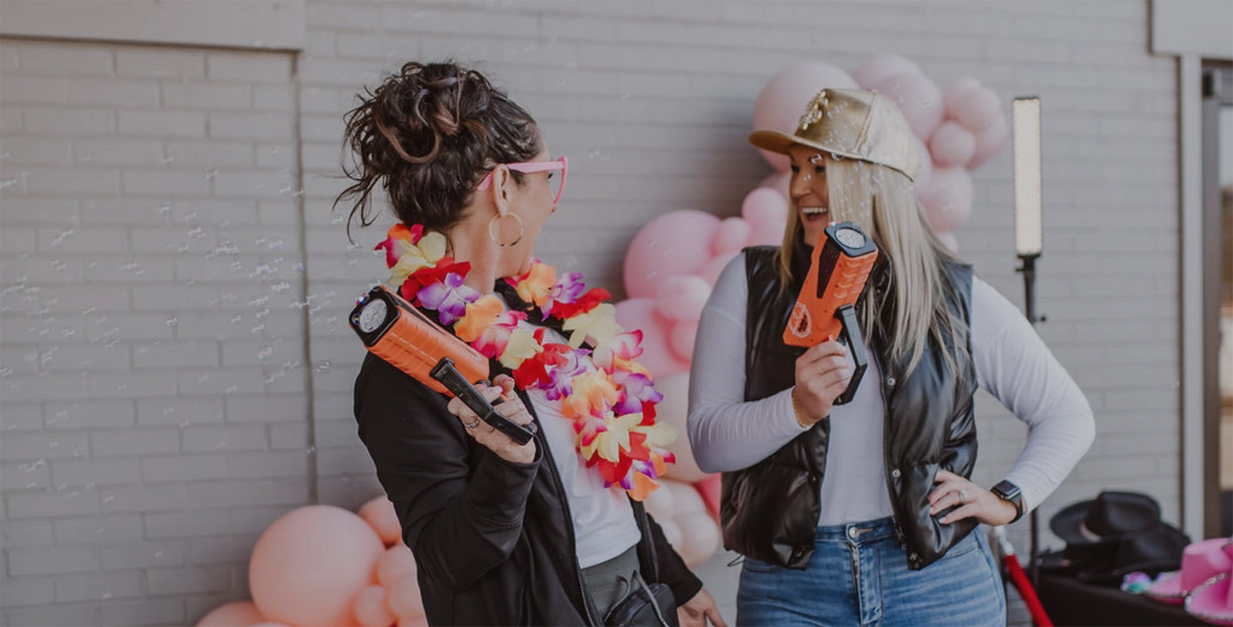 Two shoppers laughing at a Statemint pop-up consignment sale